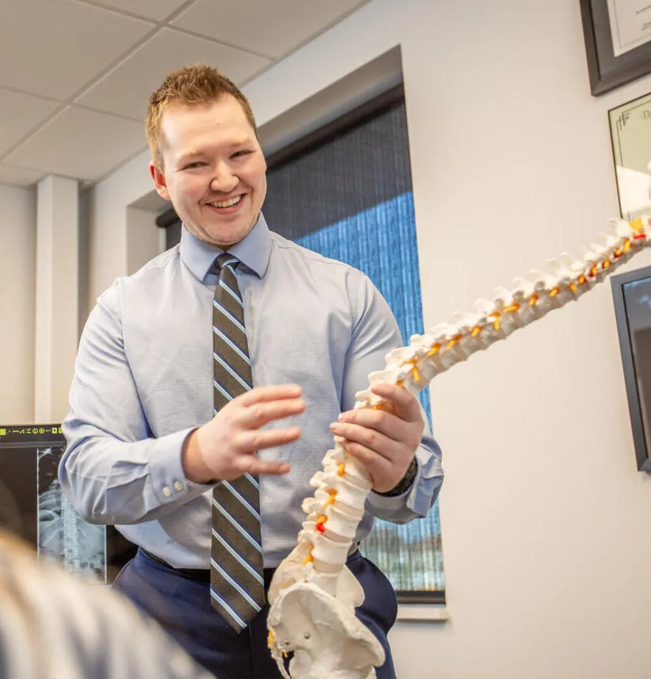 Dr. Nicholas Barney showing a patient a full spine model